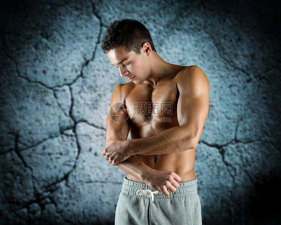 疼痛,运动,健美,健康人的轻的男健美运动员触摸受伤的肘部混凝土墙的背景图片