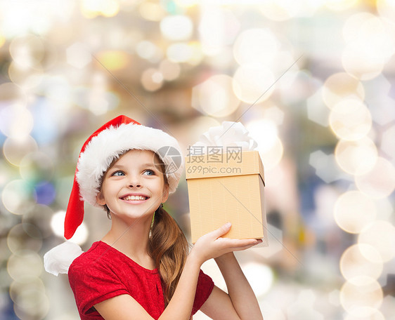 诞节,假日,童人的微笑的女孩诞老人帮助帽子与礼品盒灯光背景图片