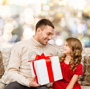 家庭,诞节,假日人的微笑的父亲女儿与礼品盒灯光背景图片