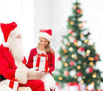 假期,童人的微笑的小女孩与诞老人礼物诞树灯光背景图片