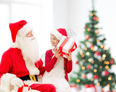 假期,童人的微笑的小女孩与诞老人礼物诞树灯光背景图片