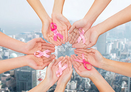 医疗保健,人医学密切妇女的手与癌症意识丝带城市背景图片