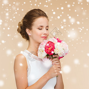 幸福,婚礼,假日庆祝微笑的新娘伴娘穿着白色连衣裙,带着米色背景雪上的花图片