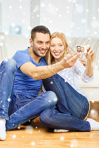 爱,家庭,技术幸福的微笑的夫妇家里用数码相机拍摄自画像图片