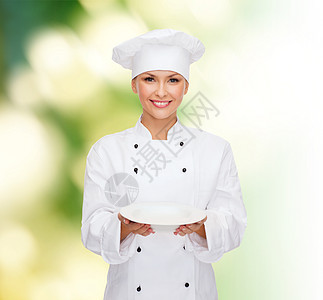 人,烹饪食物的微笑的女厨师,厨师包师与空绿色背景图片