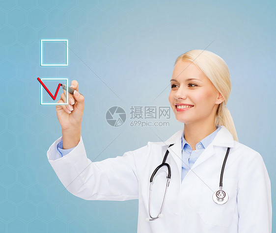 医疗保健,医学技术微笑的轻女医生画标记,以复选框蓝色背景图片