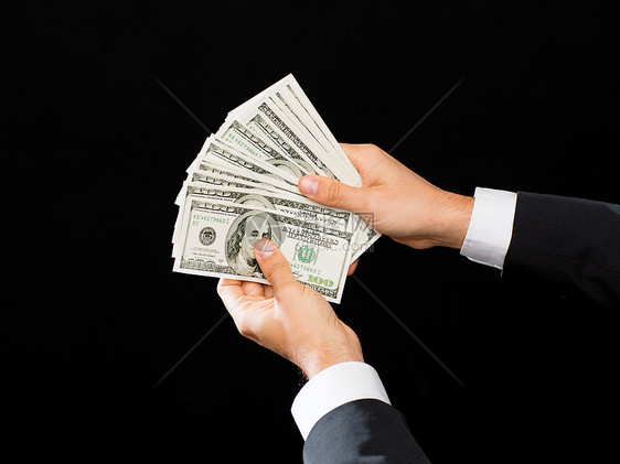 财务,人,储蓄财富密切的男手中持美元现金的黑色背景图片