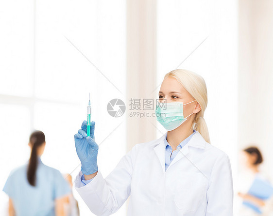 医疗保健医学戴口罩手套的女医生着蓝色背景的注射器图片