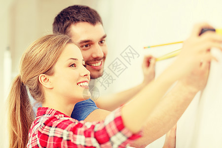 维修,建筑家庭微笑夫妇测量墙图片