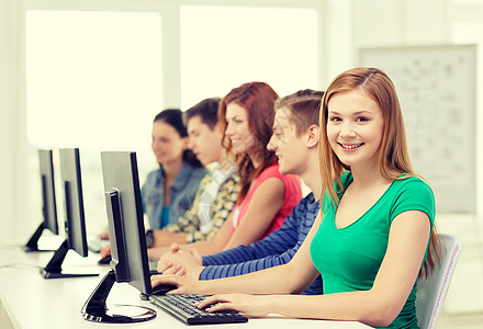教育技术学校理念微笑的女学生与同学学校的计算机高清图片