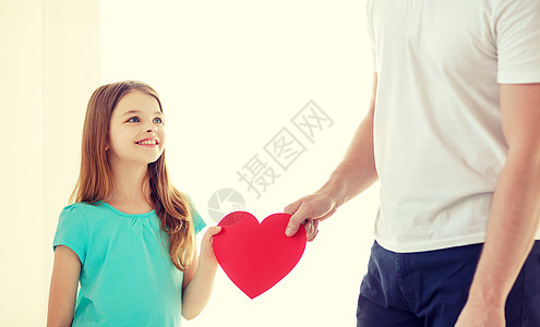 家庭孩子,健康,慈善爱的微笑的小女孩父亲抱着红色的心图片