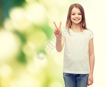 手势快乐的人微笑的小女孩穿着白色空白T恤,用手指表现出平的姿态图片