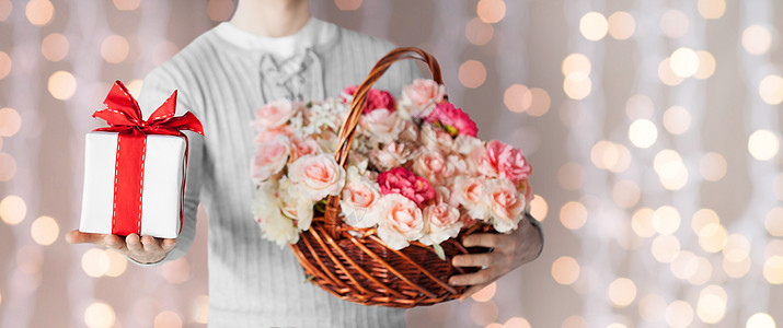 节日,人,感情问候的特写的人着装满花的篮子礼品盒灯光背景上图片