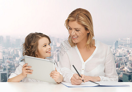 人,家庭,家庭教育,儿童技术快乐的母亲女儿与平板电脑笔记本电脑城市背景图片