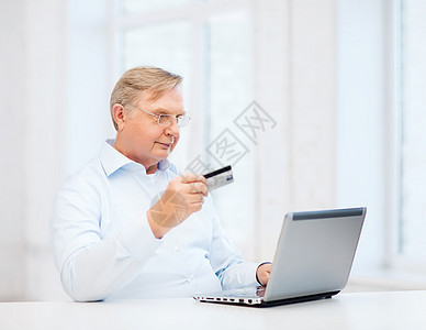 商业,网上银行,网上购物老观念微笑的老人带着笔记本电脑信用卡家图片