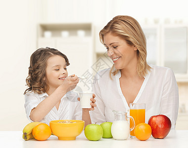 人们,健康的生活方式,家庭食物的快乐的母亲女儿家庭厨房背景下吃健康的早餐图片