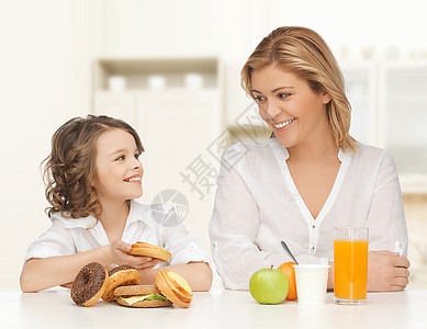 人们,健康的生活方式,家庭健康的食物快乐的母亲女儿家庭厨房背景下吃同的食物图片