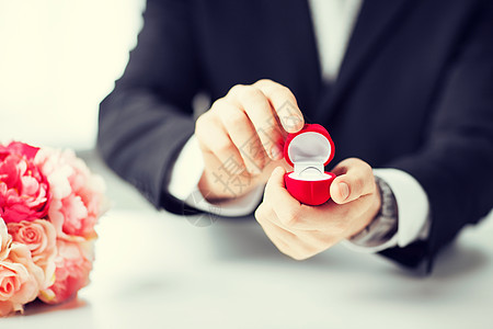 带礼品盒结婚戒指的男人的照片图片