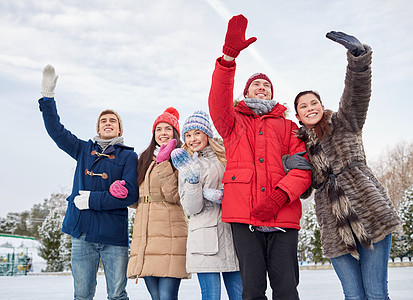 人们,冬天,友谊,运动休闲的快乐的朋友户外溜冰场上挥手图片