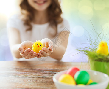复活节,假期孩子的女孩着鸡肉玩具碗彩色鸡蛋桌子上的灯光背景图片