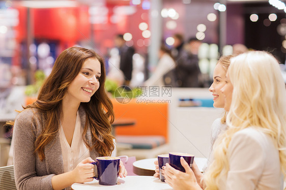 饮料,沟通,友谊人的快乐的轻女人坐桌子上,商场咖啡馆里交谈图片