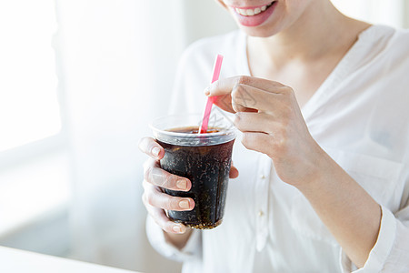 饮料,人生活方式的接近快乐的女人喝可口可乐塑料杯与稻草家图片