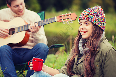 冒险,旅行,旅游人的微笑夫妇与吉他露营图片