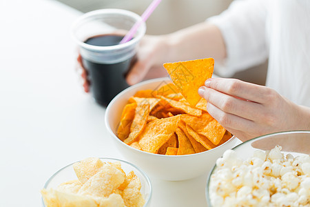 人们,快餐,垃圾食品健康的饮食观念密切妇女与爆米花,玉米片玉米薯片花生碗里图片