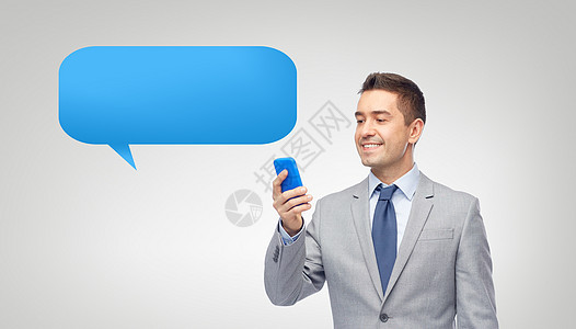 商业,人技术快乐的商人短信阅读信息智能手机上的信短信泡沫灰色背景图片