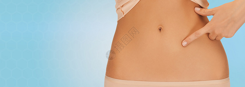 健康,消化,美丽,人减肥的近距离的女人指着腹部的蓝色背景图片