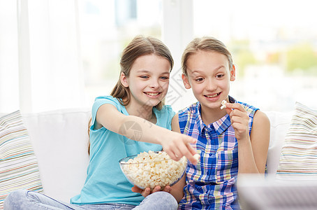 人孩子电视朋友友谊的两个快乐的小女孩家看电视吃爆米花图片