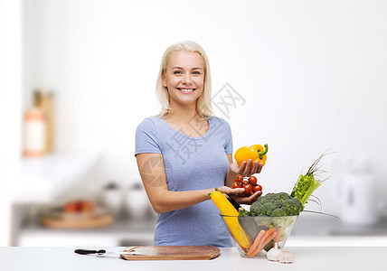 健康的饮食,烹饪,素食,饮食人们的微笑的轻妇女与碗蔬菜家庭厨房背景图片