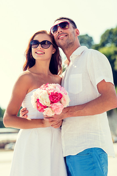 爱情,婚礼,夏天,约会人们的微笑的夫妇戴着太阳镜,带着鲜花拥抱城市里