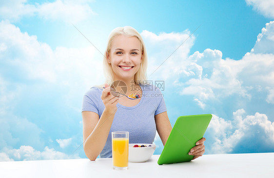 健康的饮食,饮食人的微笑的轻妇女与平板电脑吃早餐蓝天云的背景图片