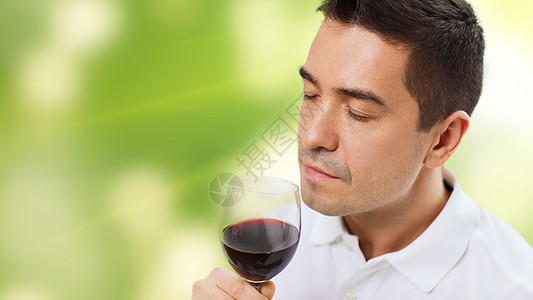 职业,饮料,休闲人的快乐的人喝闻红酒璃绿色背景图片
