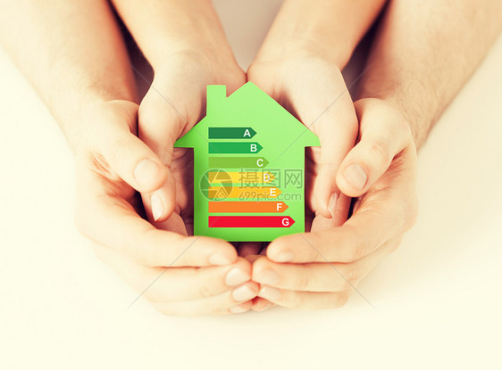 节能,房地产家庭住宅的特写夫妇手绿色纸房的能源效率评级图片