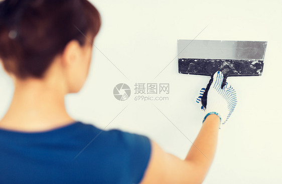 室内家庭装修妇女用铲子抹灰墙壁图片