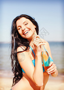 暑假,假期海滩女孩海滩上喝瓶饮料图片