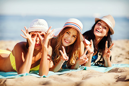 暑假假期女孩们海滩上晒太阳图片