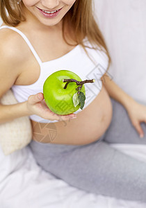 怀孕,食物,健康饮食,人期望密切快乐的孕妇家吃青苹果图片