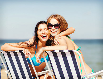 暑假假期比基尼女孩海滩椅子上晒太阳女孩们海滩椅子上晒太阳图片