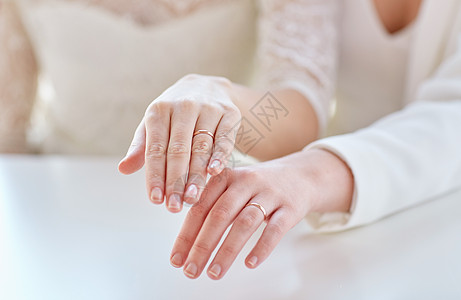 人,同婚姻爱情亲密的快乐女夫妇的手结婚戒指上图片