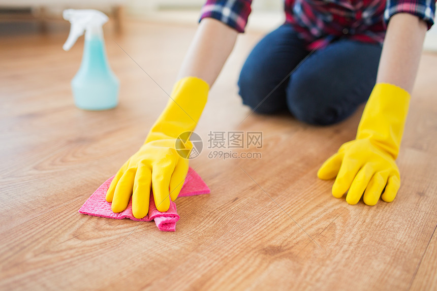 人,家务家务妇女橡胶手套与布洗涤剂喷雾清洁地板家里图片