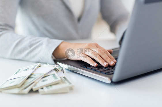 商业,金融,储蓄,技术人的密切妇女的手与笔记本电脑美元的钱图片
