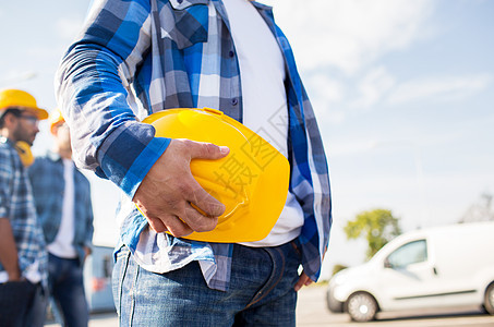 建筑,防护装备人的靠近建筑工人手黄色安全帽头盔施工场景图片