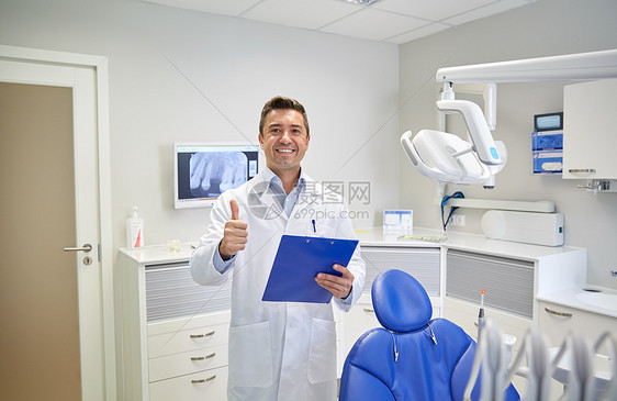 人,医学,口腔医学保健快乐的中男牙医穿着白色外套,剪贴板大拇指牙科诊所办公室图片