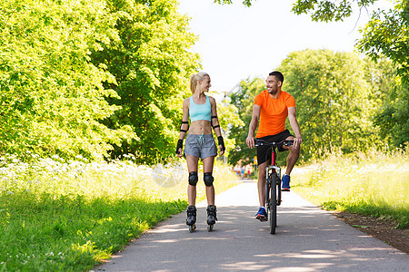 健身,运动,夏天,人健康的生活方式快乐的夫妇与溜冰鞋自行车骑户外交谈夏天图片