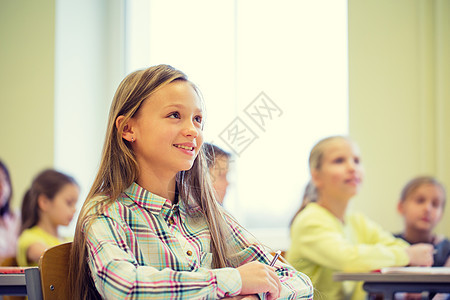 教育,小学,学人的群带笔记本的孩子坐教室里图片