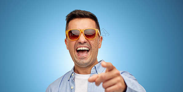 夏天,风格,情感人的笑的中拉丁男子穿着衬衫太阳镜蓝色背景图片