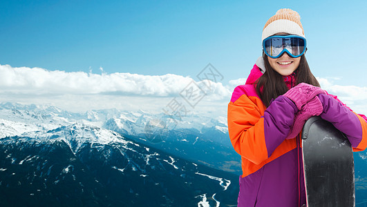 冬季,休闲,运动人的快乐的轻妇女滑雪护目镜与滑雪板雪山背景图片